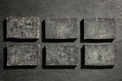 Photo of Natural tar soap on black background, flat lay