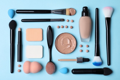 Photo of Flat lay composition with skin foundation and beauty accessories on color background