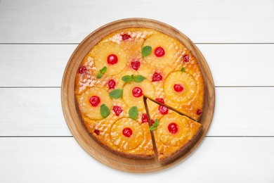 Photo of Delicious cut pineapple pie with cherry and mint on white wooden table, top view