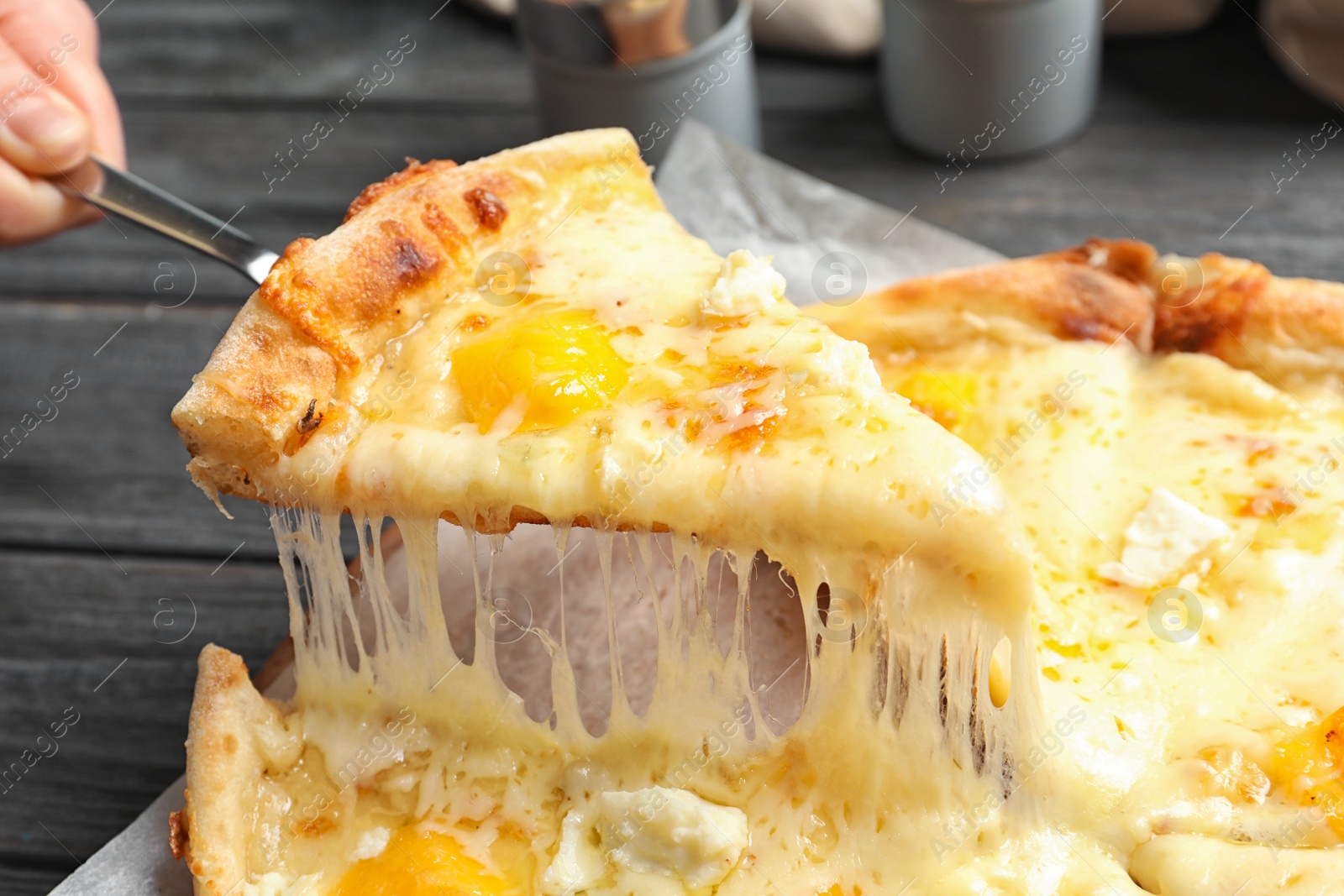 Photo of Woman taking slice of hot cheese pizza Margherita on table, closeup