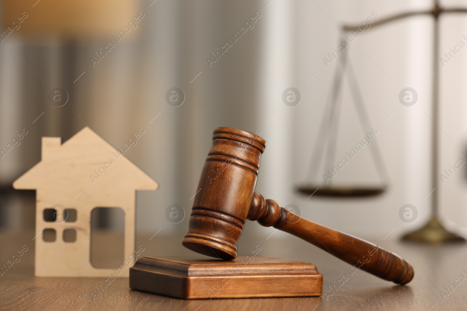 Photo of Law concept. Gavel and figure of house on wooden table