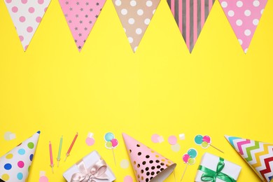Flat lay composition with party decor on yellow background. Space for text