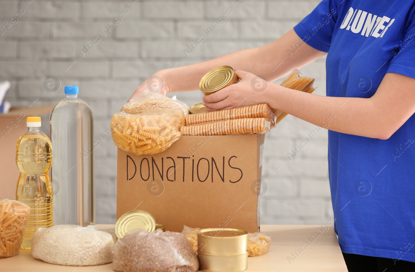 Photo of Volunteer collecting food into donation box indoors