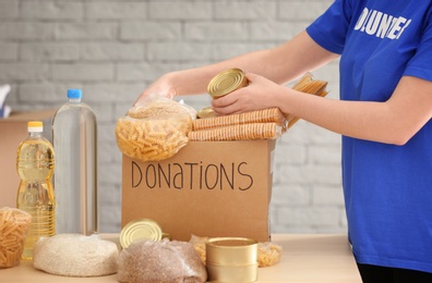 Photo of Volunteer collecting food into donation box indoors