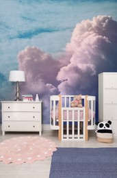 Image of Pattern of blue sky with clouds on wallpaper in furnished baby room. Beautiful interior design