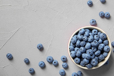 Photo of Flat lay composition with juicy and fresh blueberries on color table. Space for text