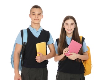 Portrait of teenagers in school uniform with books and backpacks on white background