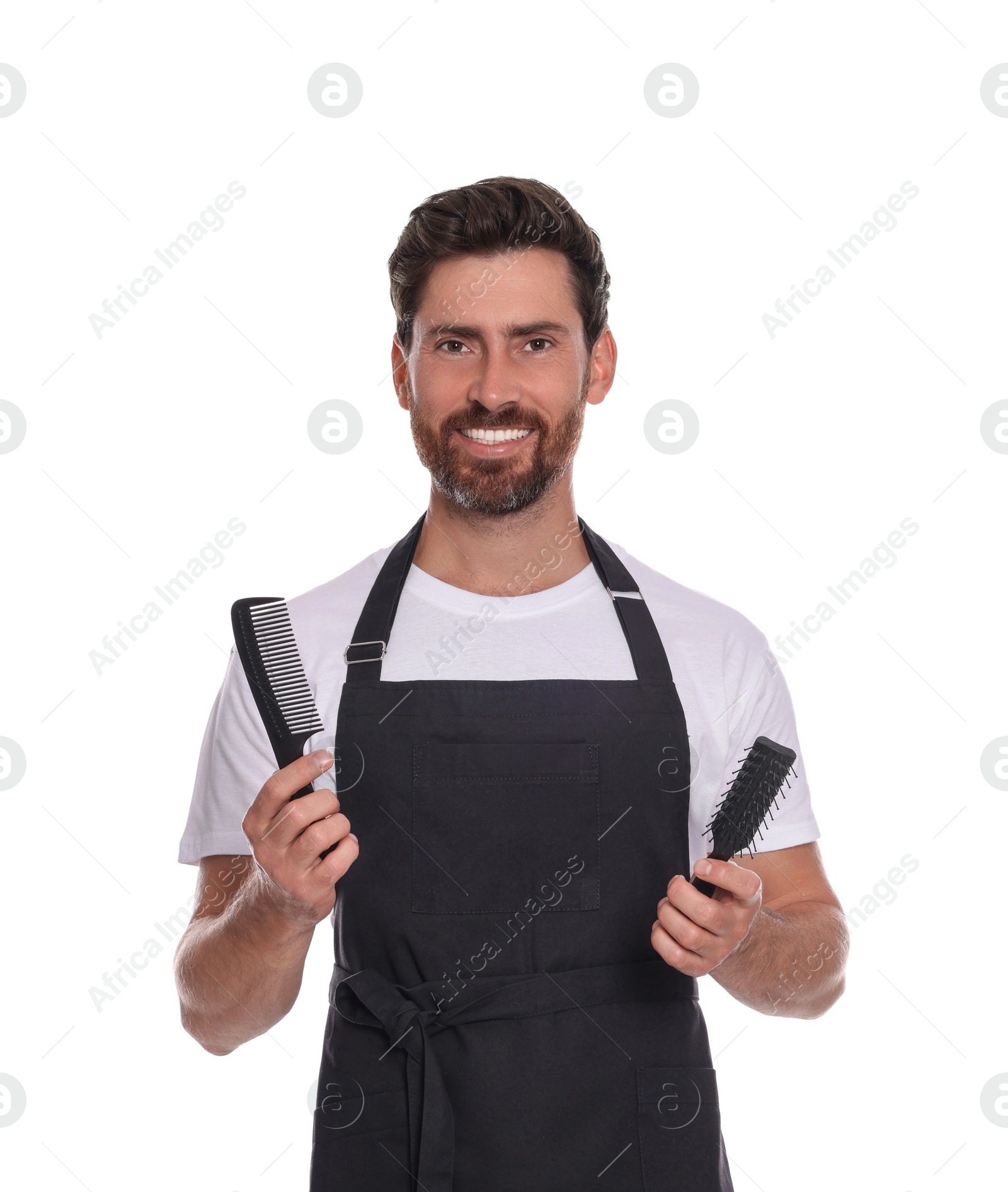 Photo of Smiling hairdresser with comb and brush on white background