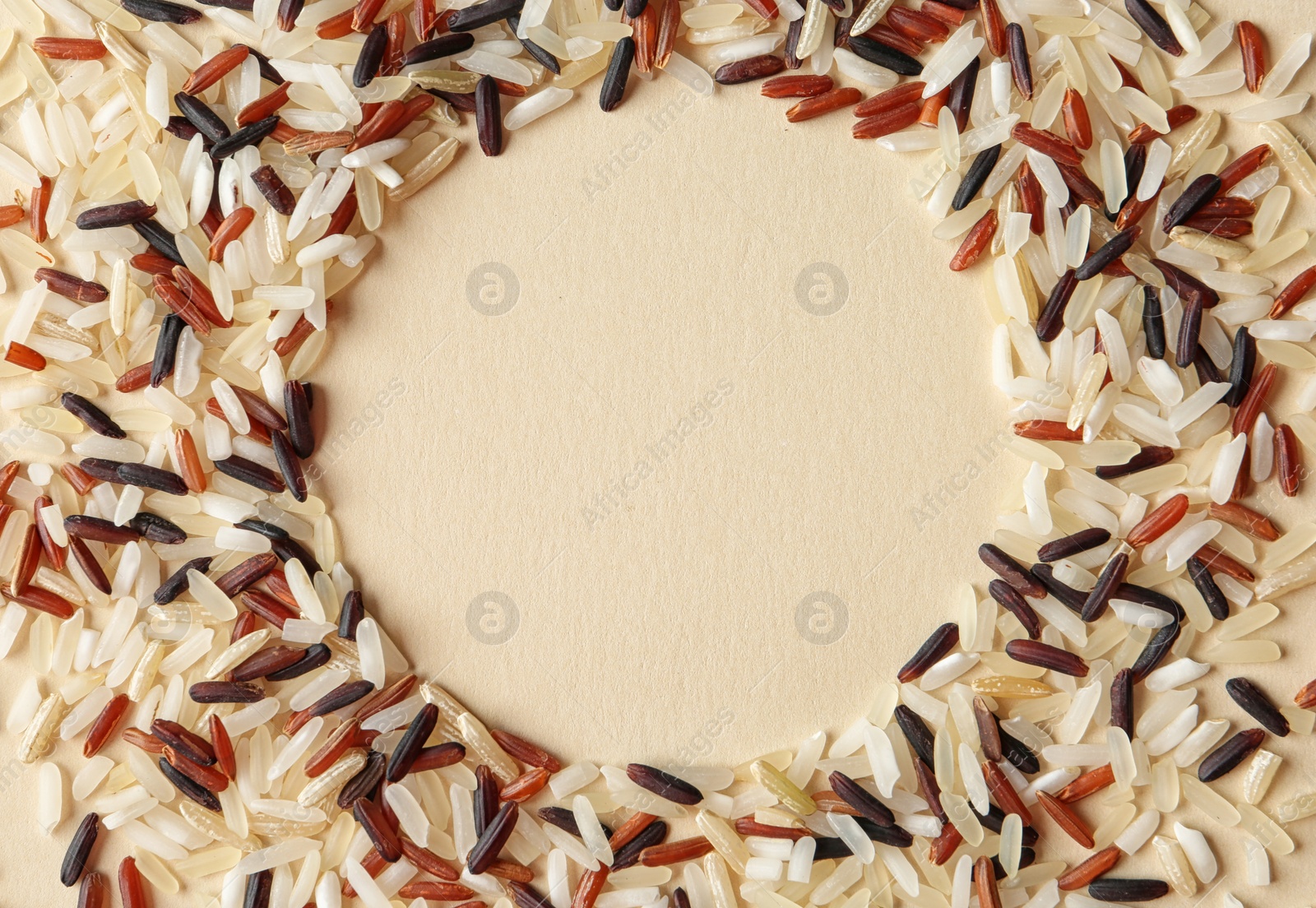 Photo of Round frame made with mixed brown and other types of rice on color background, top view. Space for text