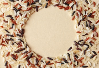 Photo of Round frame made with mixed brown and other types of rice on color background, top view. Space for text