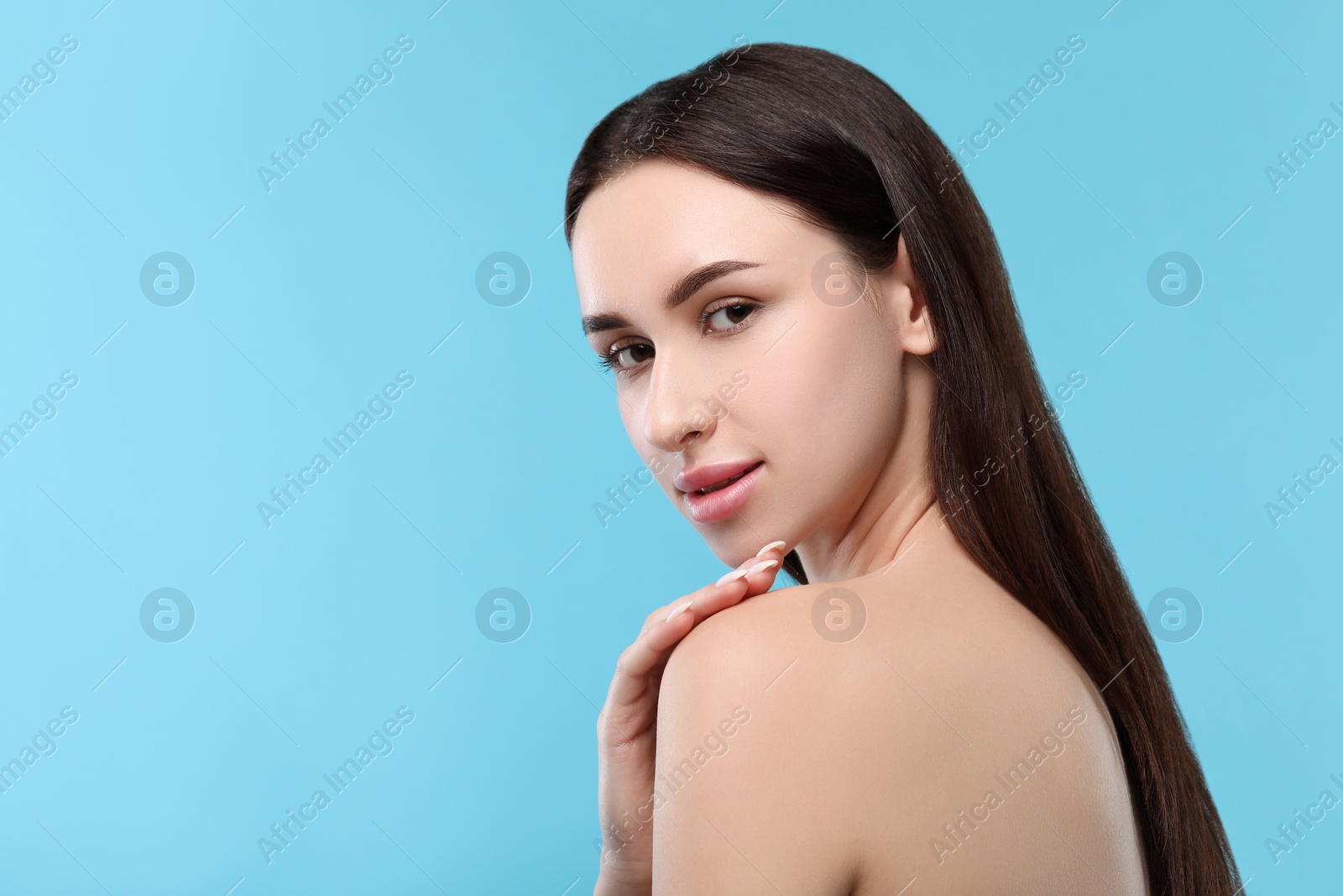 Photo of Portrait of beautiful young woman on light blue background. Space for text