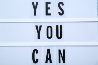 Photo of Lightbox with phrase Yes You Can, closeup. Motivational quote