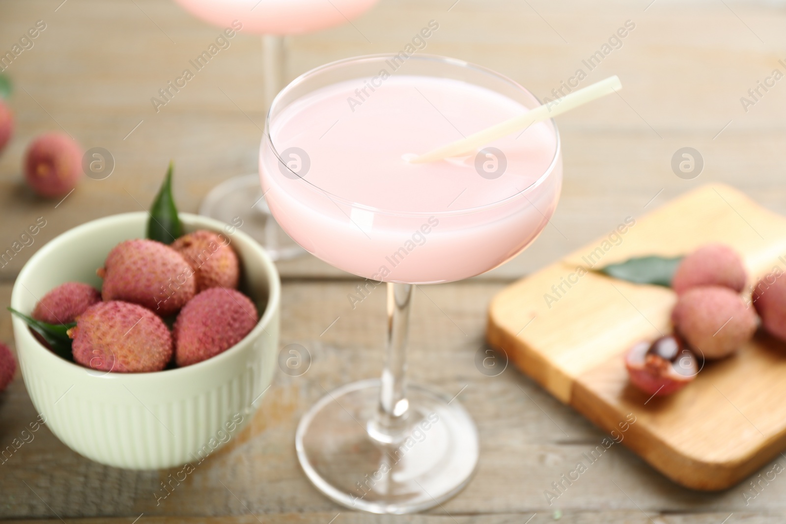 Photo of Delicious lychee cocktail and fresh fruits on wooden table, closeup
