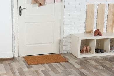 Hallway interior with shoe rack and mat near door