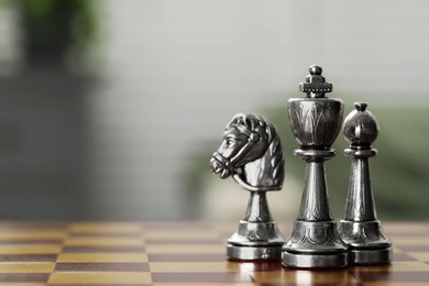 Photo of Silver king, bishop and knight on chess board, closeup. Space for text