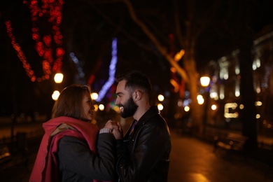 Photo of Lovely couple spending time in city at night