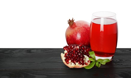 Photo of Refreshing pomegranate juice in glass, leaves and fruits on black wooden table against white background. Space for text