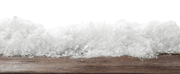 Photo of Snow on wooden surface against white background. Christmas season