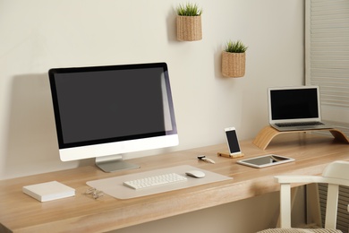 Stylish workplace interior with modern computer on table. Mockup for design