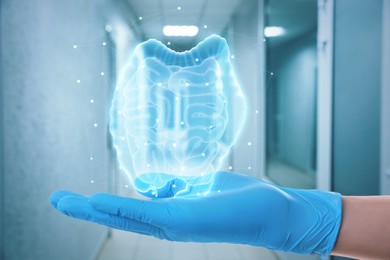 Gastroenterologist holding virtual image of intestine indoors, closeup