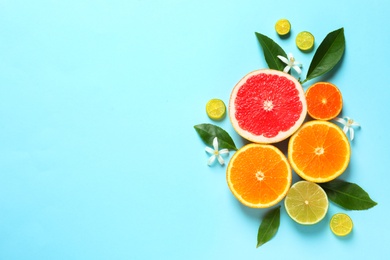 Photo of Flat lay composition with citrus fruits, leaves and flowers on color background. Space for text