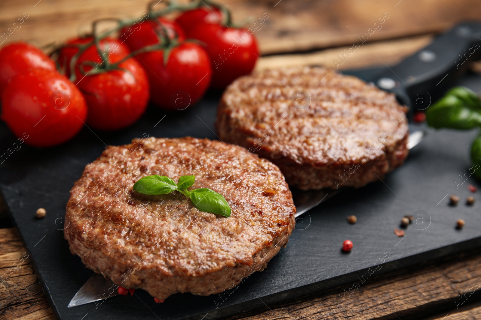 Photo of Tasty grilled hamburger patties served on wooden table, closeup