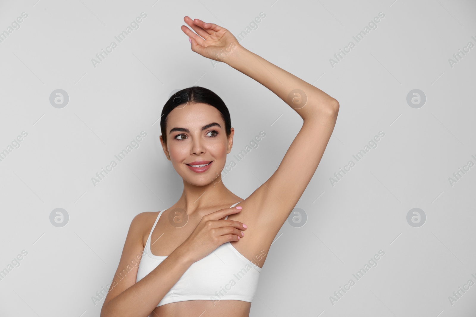Photo of Young woman showing smooth skin after epilation on white background, space for text