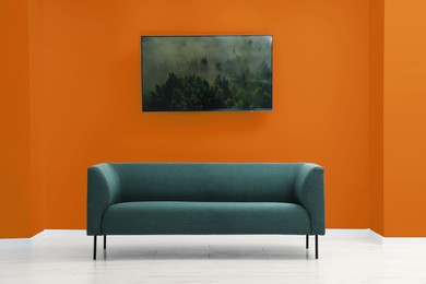 Photo of Beautiful interior with sofa near orange wall