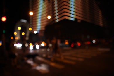 Photo of Blurred view of people crossing street in city. Night life