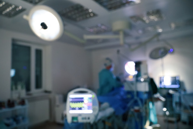 Photo of Blurred view of doctors operating patient in surgery room