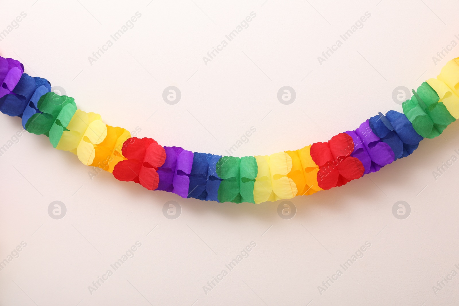 Photo of Rainbow paper garland on beige background. LGBT pride