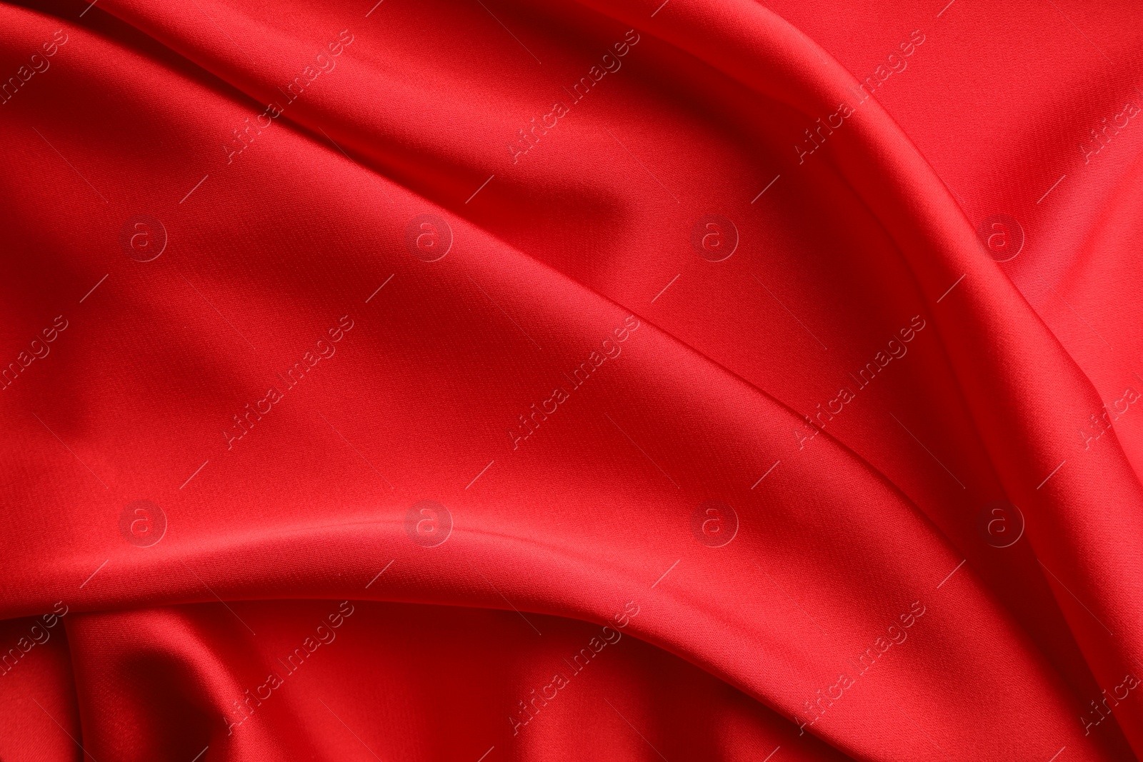 Photo of Crumpled red silk fabric as background, top view