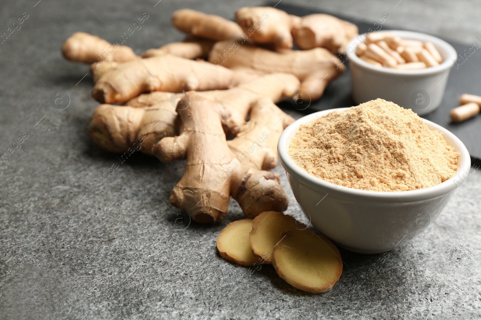 Photo of Dry, fresh and capsuled ginger on grey table. Space for text