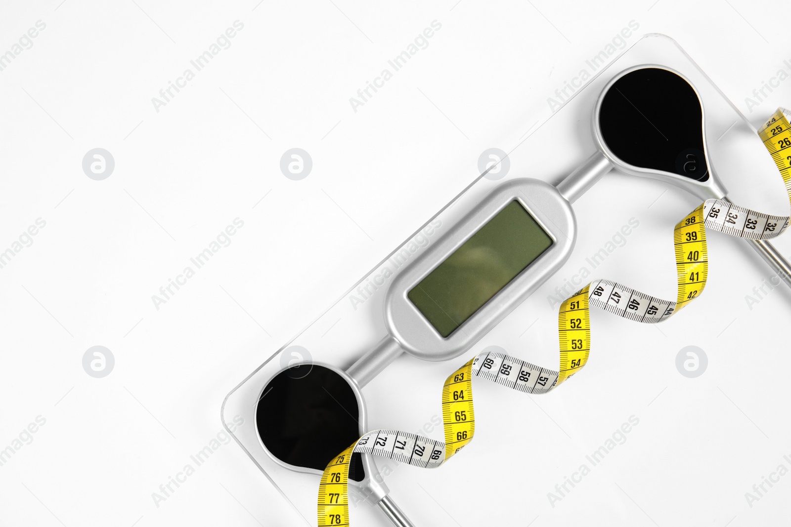 Photo of Modern scales and tape measure isolated on white, top view