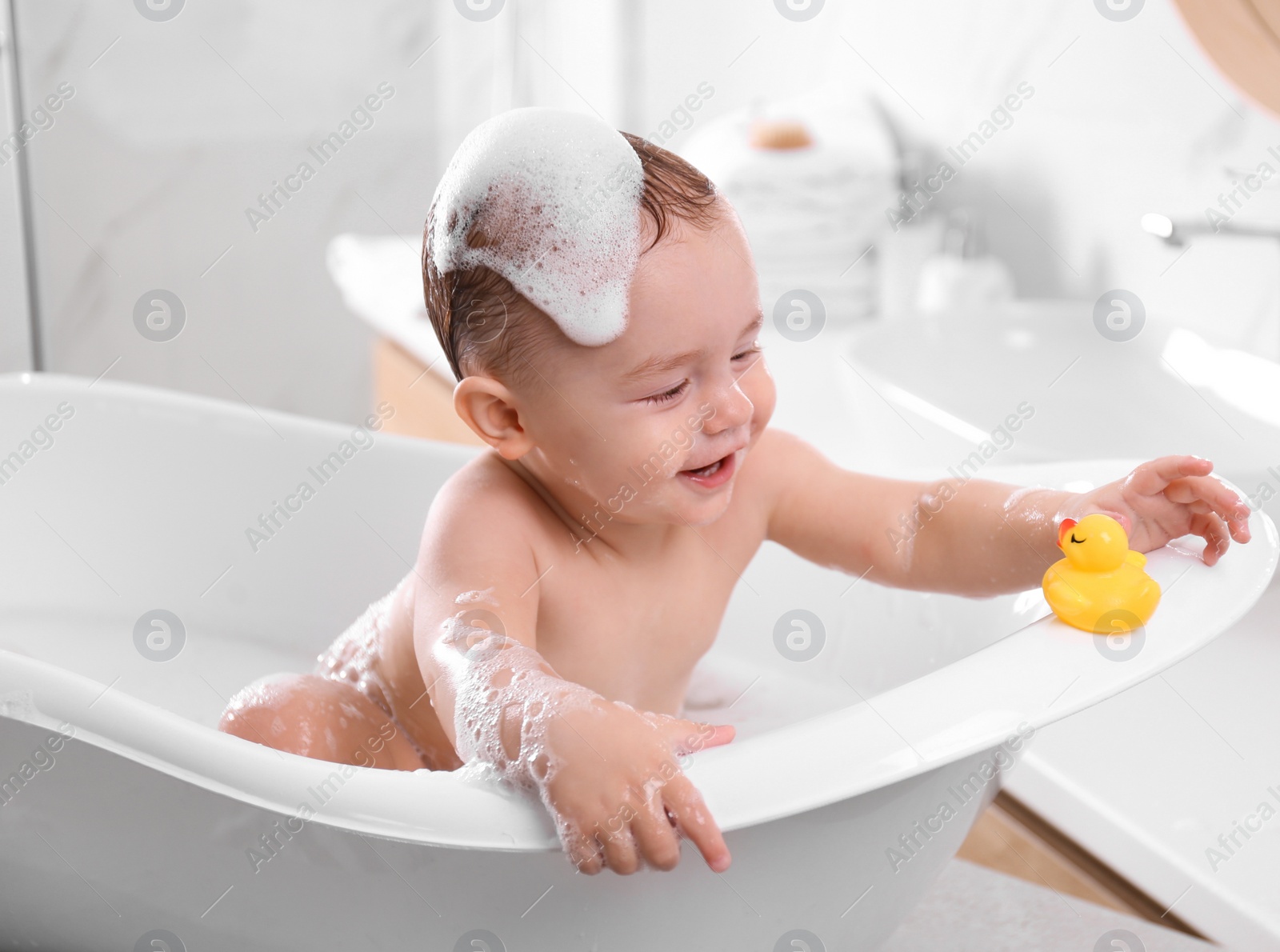 Photo of Cute little baby in bathtub at home