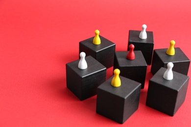 Photo of Black blocks with playing pieces on red background, space for text. Roles and responsibility concept