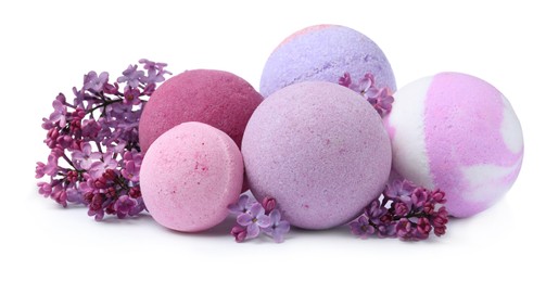 Photo of Fragrant bath bombs and lilac flowers on white background