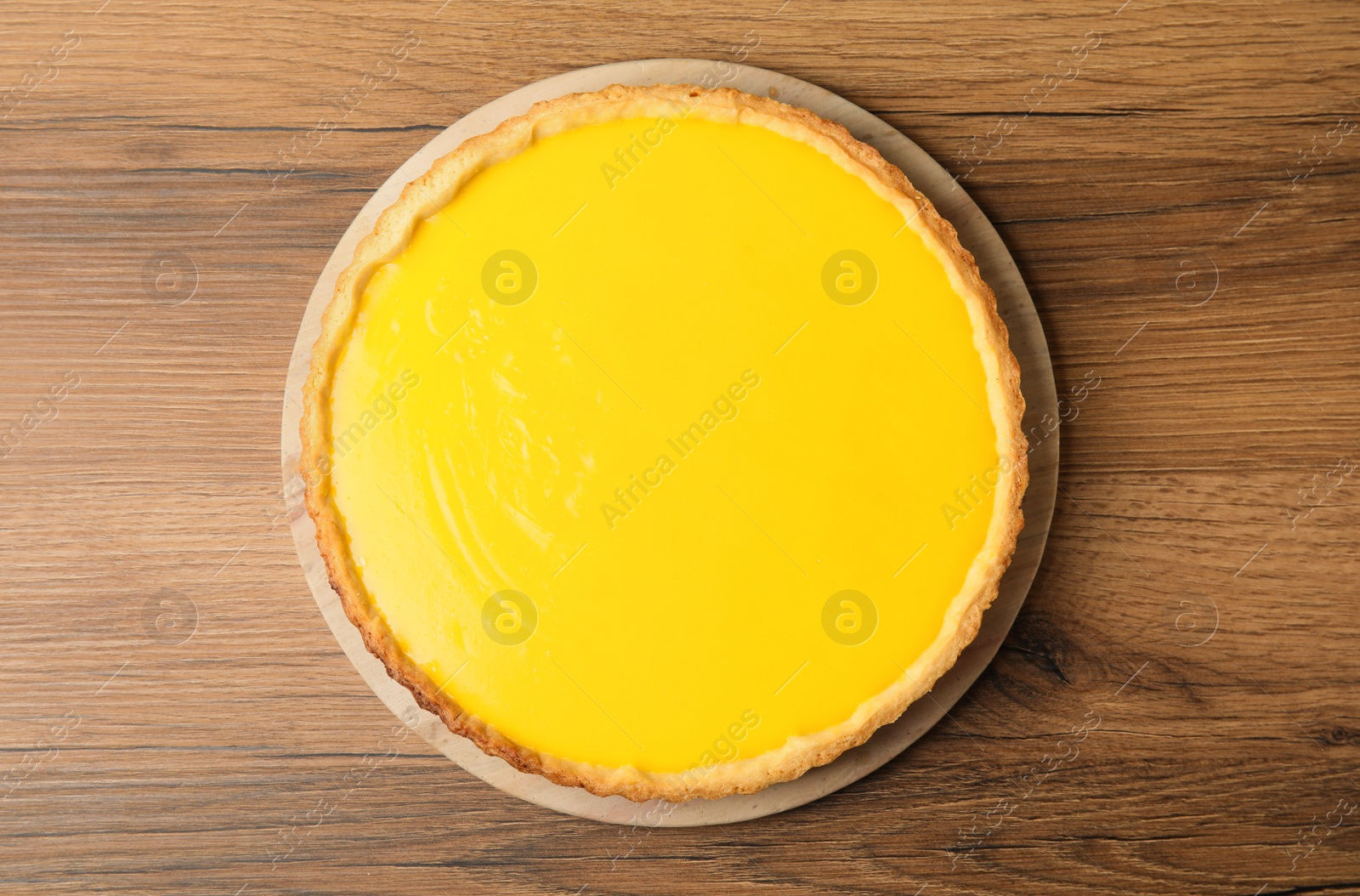 Photo of Delicious homemade lemon pie on wooden table, top view