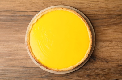 Photo of Delicious homemade lemon pie on wooden table, top view