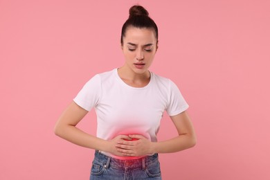 Image of Woman suffering from stomach pain on pink background