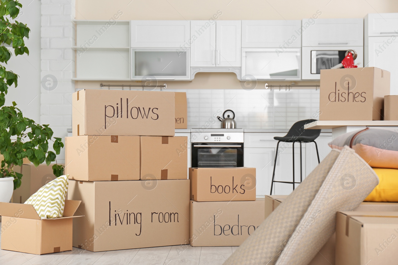 Photo of Cardboard boxes and household stuff in kitchen. Moving day