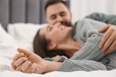 Affectionate young couple spending time together on bed, selective focus