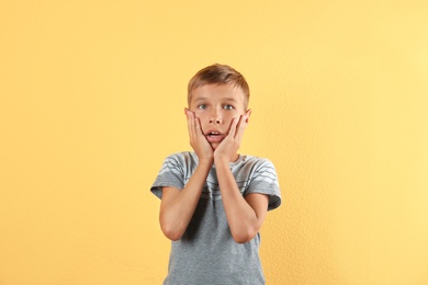 Photo of Adorable little boy in casual clothes on color background