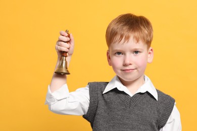 Photo of Pupil with school bell on orange background