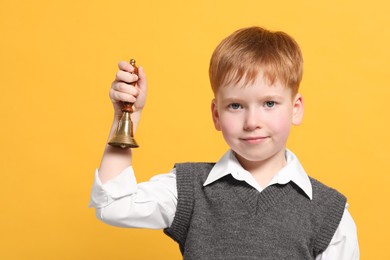 Pupil with school bell on orange background