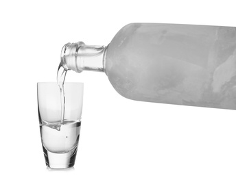 Pouring cold vodka into shot glass on white background