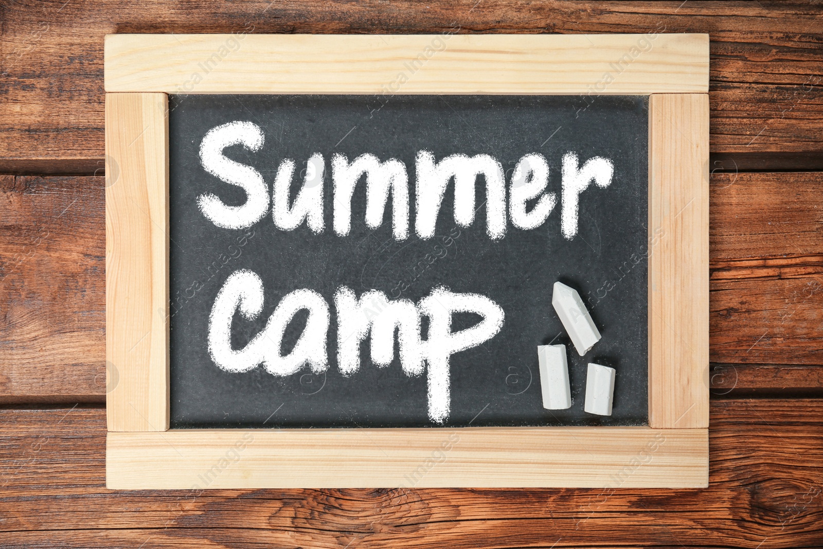 Image of Blackboard with text SUMMER CAMP on wooden background, top view