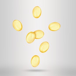 Image of Vitamin. Softgel capsules falling on light grey background