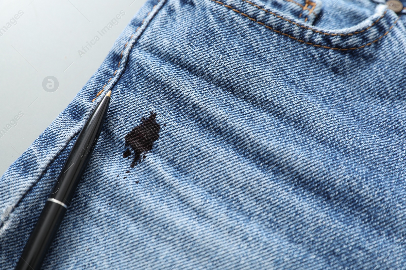 Photo of Pen and stain of black ink on jeans, closeup. Space for text