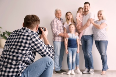 Photo of Professional photographer taking photo of family in studio